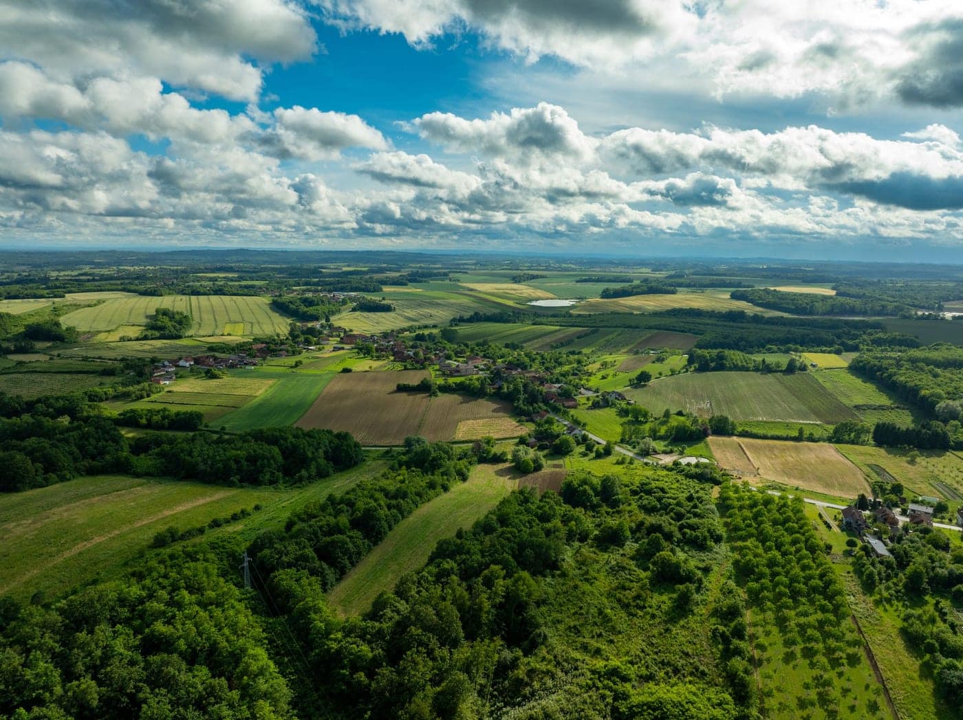 Vista aérea de propriedade rural com lavouras e áreas de mata preservada
